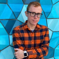 Nathan Smith posing in front of a blue mosaic wall.