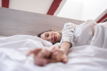 Young female resting on bed in morning